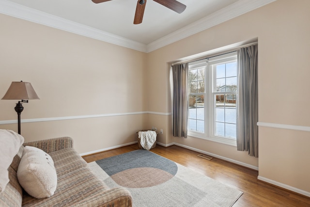 living area featuring ceiling fan, light hardwood / wood-style flooring, and ornamental molding