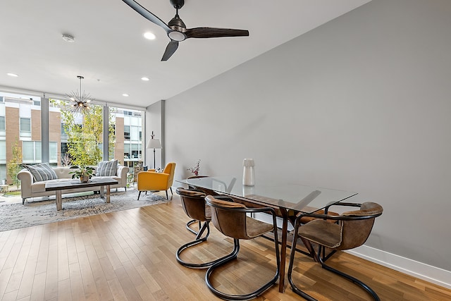 dining space with light wood-type flooring, ceiling fan, and floor to ceiling windows