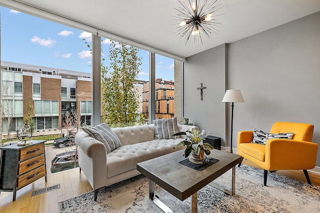 living room with light hardwood / wood-style flooring, a chandelier, and expansive windows