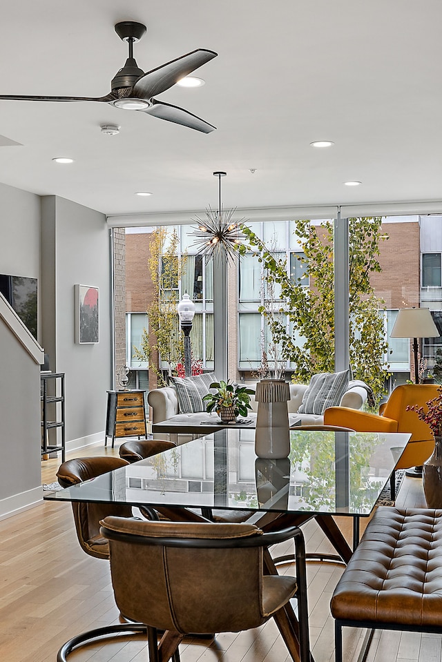 dining area with light wood-type flooring, ceiling fan, and expansive windows