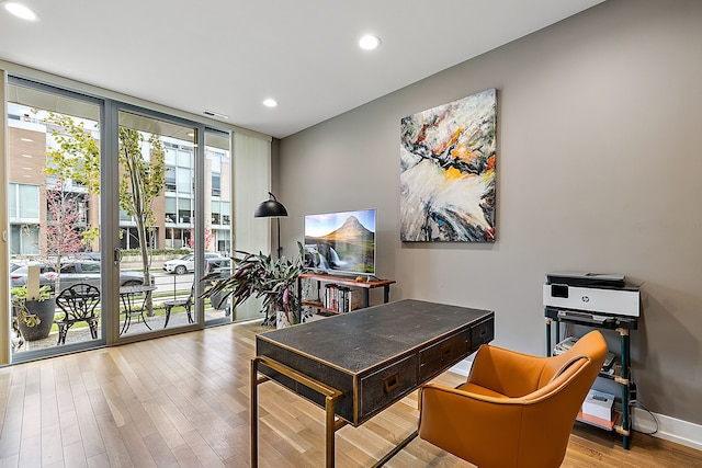 office space with light hardwood / wood-style flooring and a wall of windows