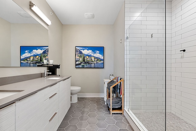 bathroom with vanity, a tile shower, toilet, and tile patterned floors