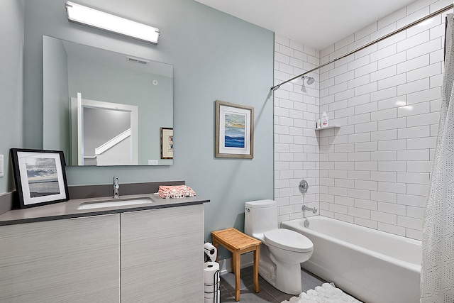 full bathroom featuring tiled shower / bath combo, vanity, and toilet