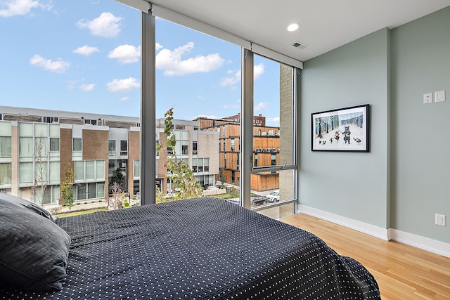 bedroom featuring hardwood / wood-style floors and a wall of windows