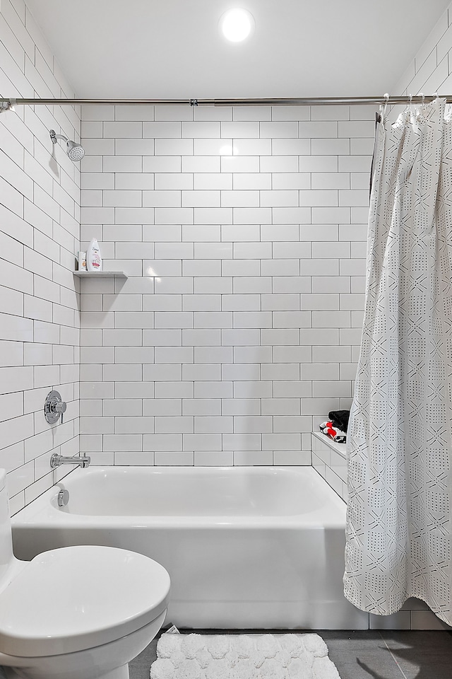 bathroom featuring shower / tub combo and toilet