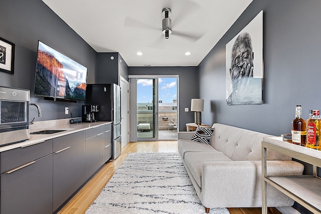 living room with light hardwood / wood-style floors and sink