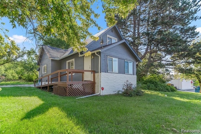 exterior space with a front lawn and a wooden deck