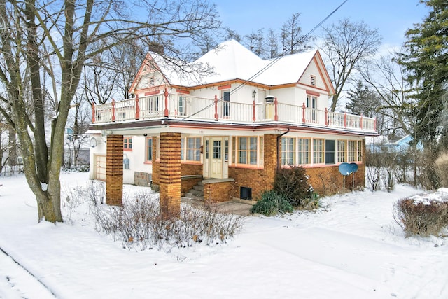 view of front facade with a balcony and brick siding