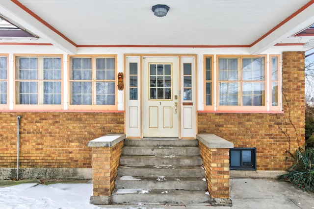 doorway to property with brick siding