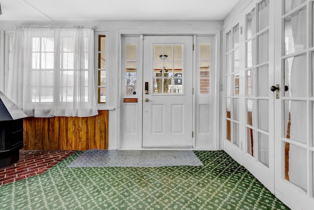 entryway with tile patterned floors and wood walls