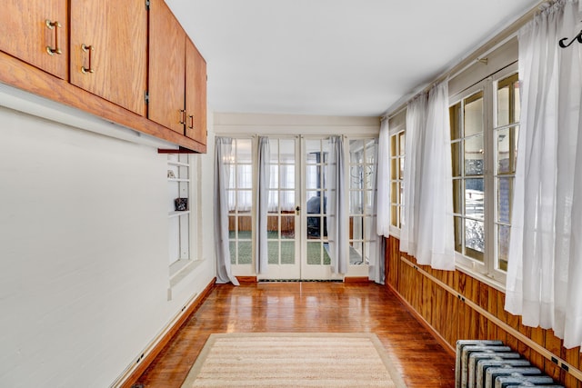 unfurnished sunroom with radiator and french doors