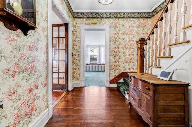 entrance foyer featuring wallpapered walls, crown molding, baseboards, radiator heating unit, and wood finished floors