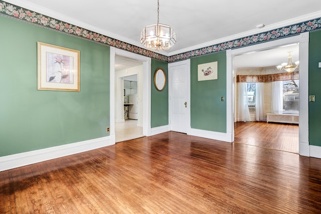 spare room with hardwood / wood-style floors, a chandelier, and ornamental molding