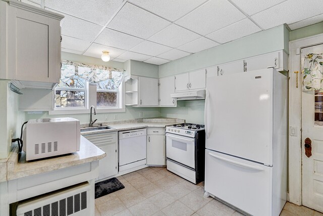 kitchen featuring a paneled ceiling, white cabinets, white appliances, and sink