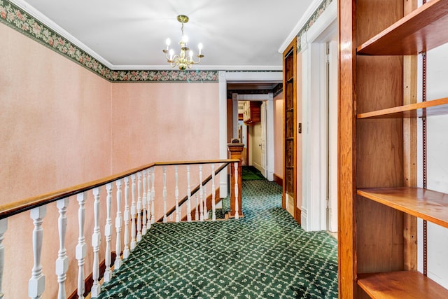 hall with an upstairs landing, a notable chandelier, carpet floors, and crown molding