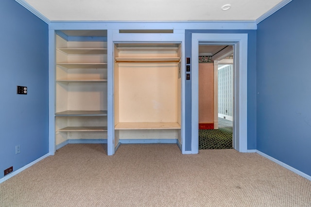 unfurnished bedroom with a closet, baseboards, ornamental molding, and carpet flooring