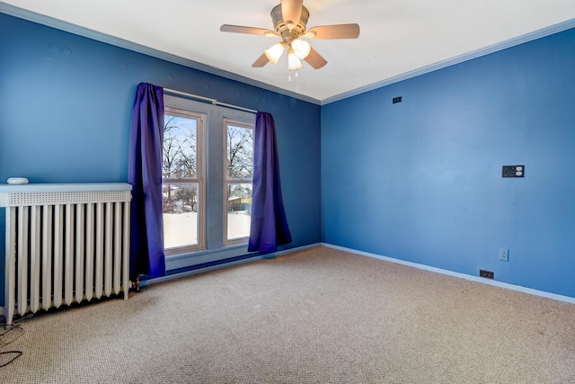 carpeted spare room featuring visible vents, crown molding, ceiling fan, baseboards, and radiator heating unit