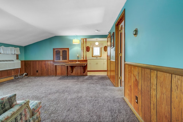 additional living space with wooden walls, wainscoting, lofted ceiling, and carpet floors