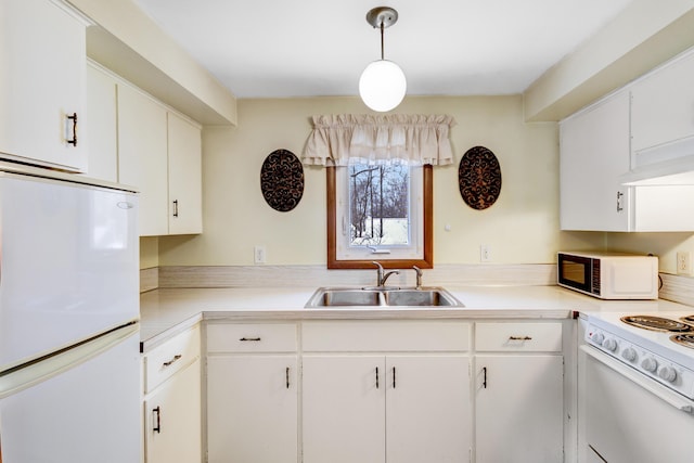 kitchen featuring white appliances, a sink, hanging light fixtures, light countertops, and white cabinetry