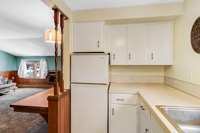 kitchen featuring carpet floors, a baseboard radiator, freestanding refrigerator, light countertops, and wainscoting