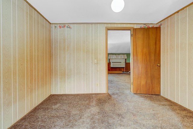 carpeted empty room featuring wooden walls