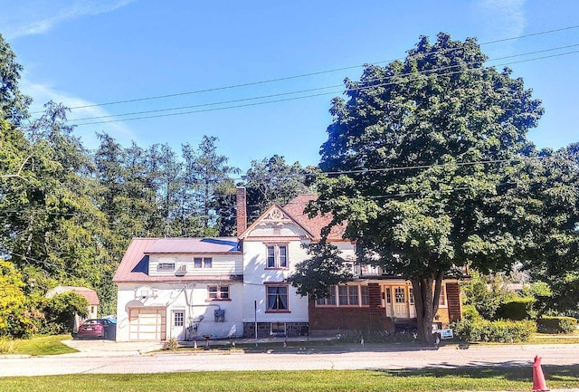 view of front facade with a garage and a chimney