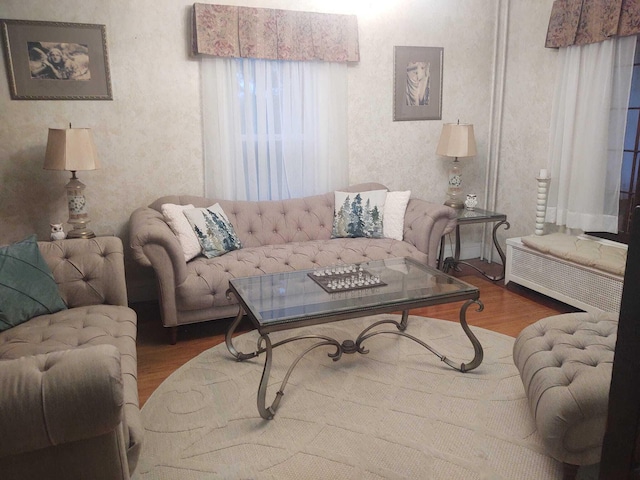 living area featuring wallpapered walls and wood finished floors