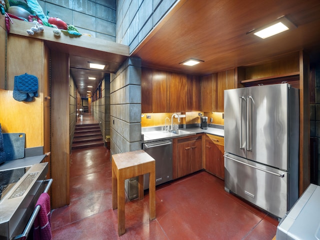 kitchen with sink, appliances with stainless steel finishes, wood walls, and wood ceiling