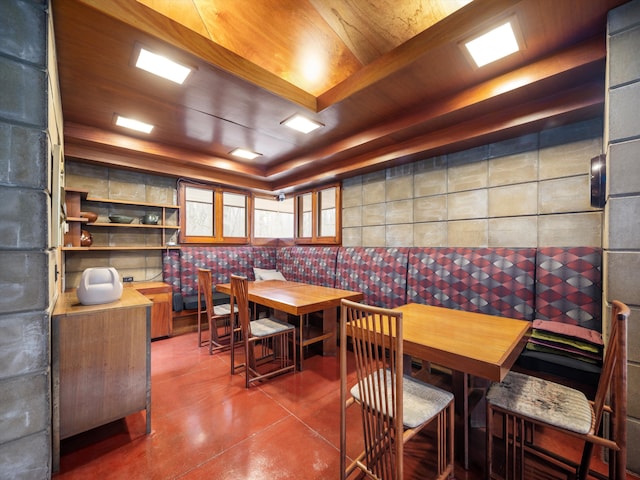 dining space with wood ceiling and a tray ceiling