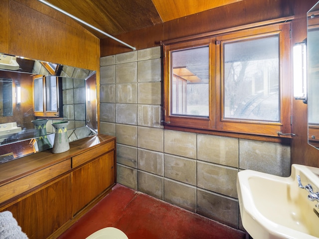 bathroom featuring sink, wood ceiling, and tile walls