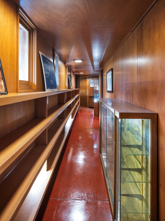 hallway featuring wooden walls