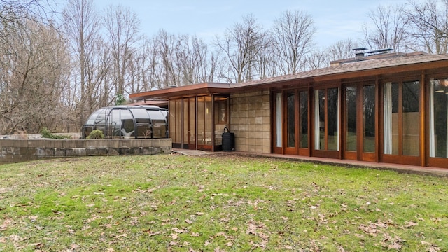 back of property with an outdoor structure and a lawn