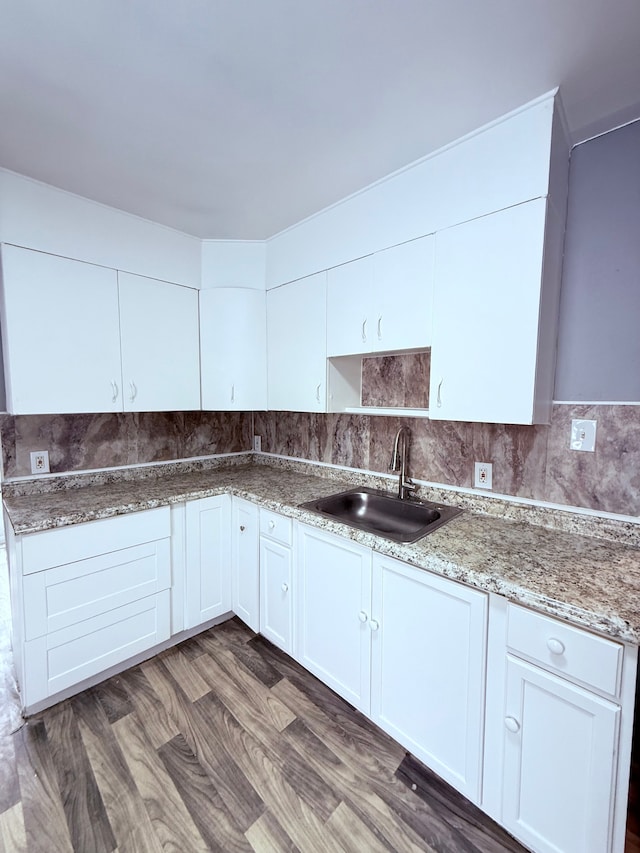 kitchen with backsplash, stone counters, white cabinets, sink, and dark hardwood / wood-style floors