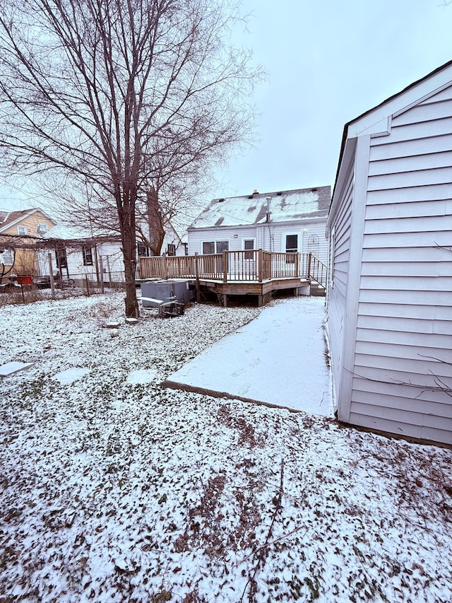 yard layered in snow with a deck