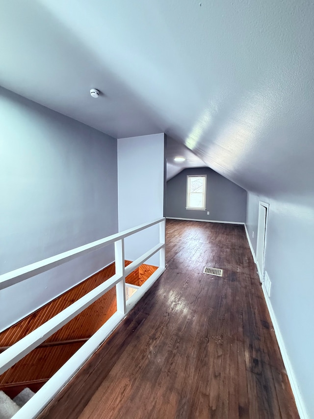 additional living space with lofted ceiling and dark wood-type flooring