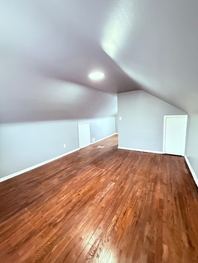 additional living space featuring wood-type flooring and lofted ceiling