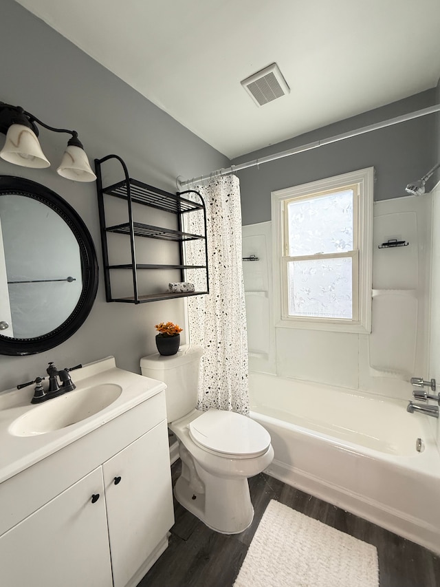 full bathroom featuring hardwood / wood-style flooring, vanity, shower / bath combination with curtain, and toilet