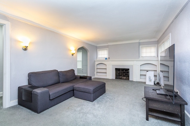 living room featuring built in shelves, light colored carpet, and ornamental molding