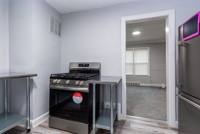 kitchen featuring hardwood / wood-style flooring and appliances with stainless steel finishes