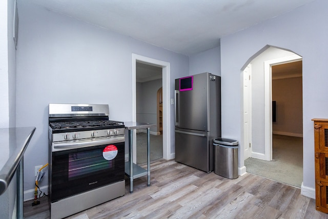 kitchen with light hardwood / wood-style floors and appliances with stainless steel finishes