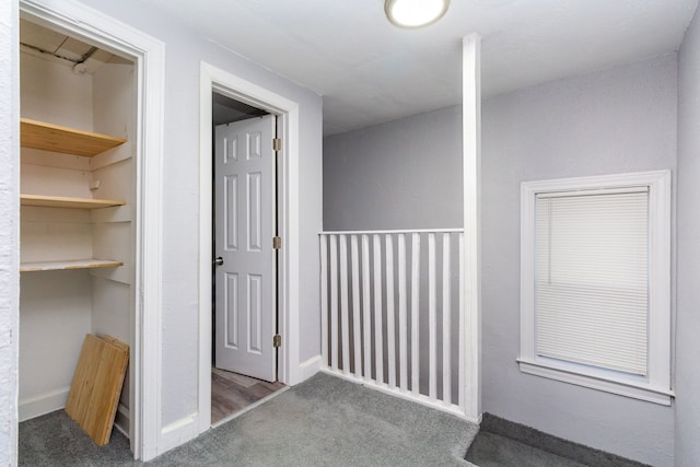 corridor featuring dark colored carpet