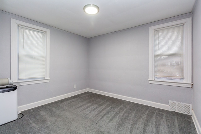 unfurnished room with dark carpet