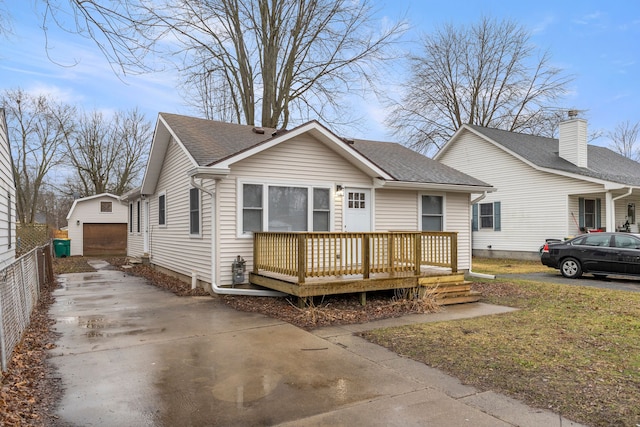 view of front of property featuring a garage, an outdoor structure, and a deck