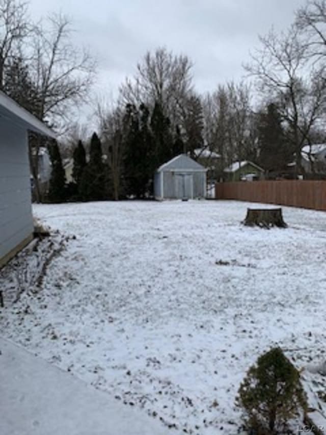 yard covered in snow with a shed