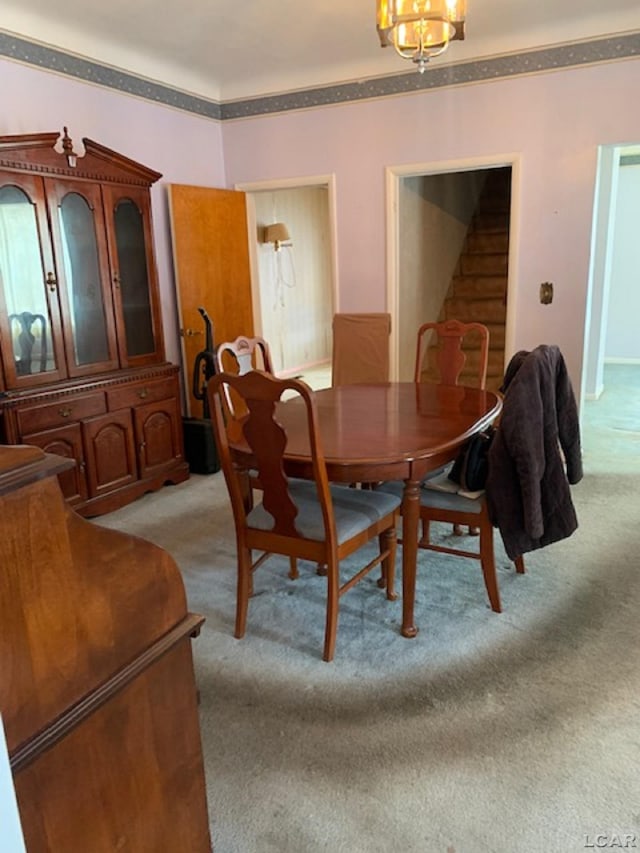 carpeted dining space with a notable chandelier