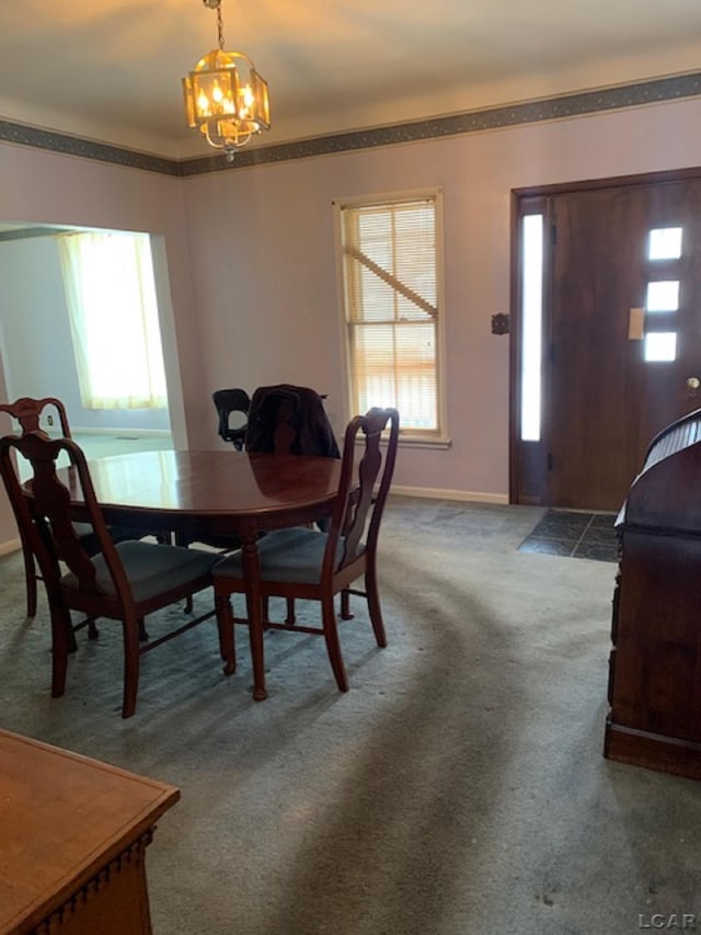 carpeted dining room featuring ornamental molding and an inviting chandelier