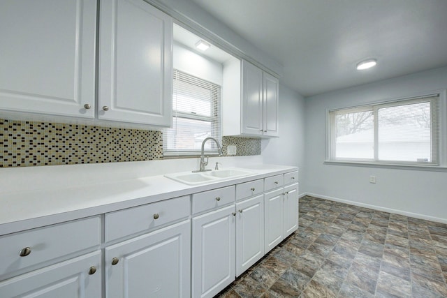 kitchen featuring white cabinets, tasteful backsplash, plenty of natural light, and sink