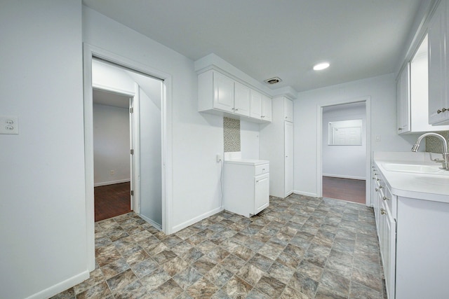 kitchen with white cabinetry and sink