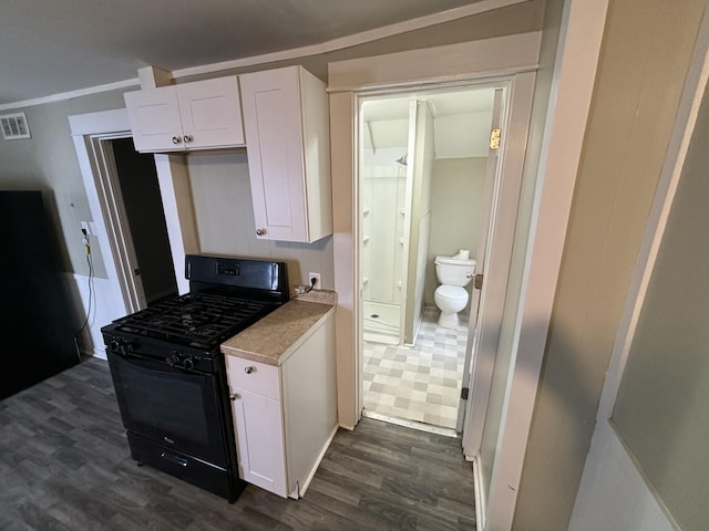 kitchen featuring white cabinets, black range with gas stovetop, dark hardwood / wood-style flooring, and ornamental molding