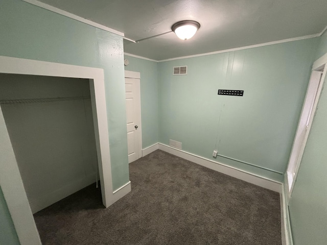 unfurnished bedroom with crown molding, a closet, and dark carpet